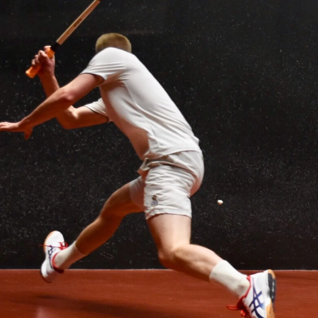Player mid-swing on the rackets court