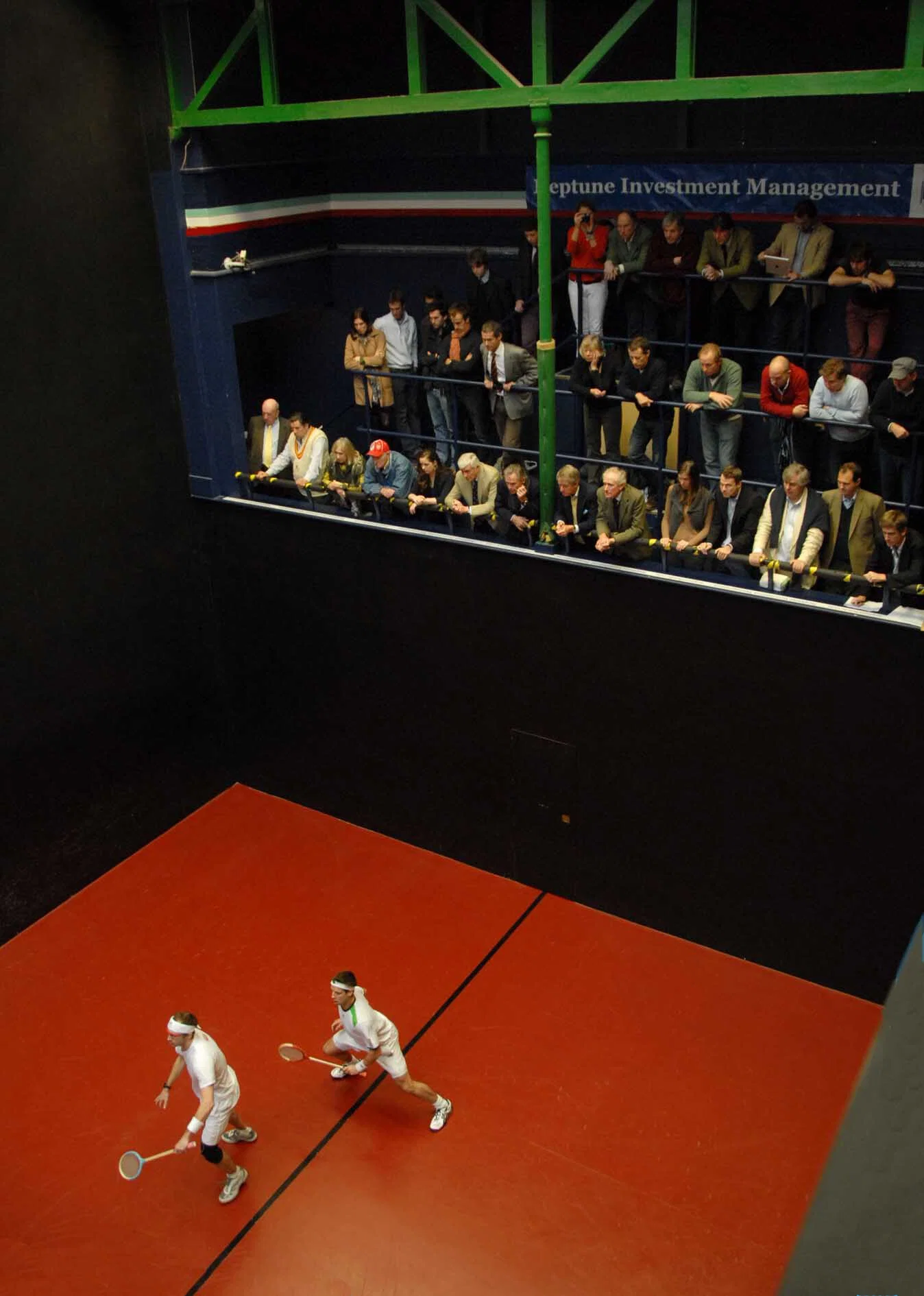 Rackets players in action, watched by spectators